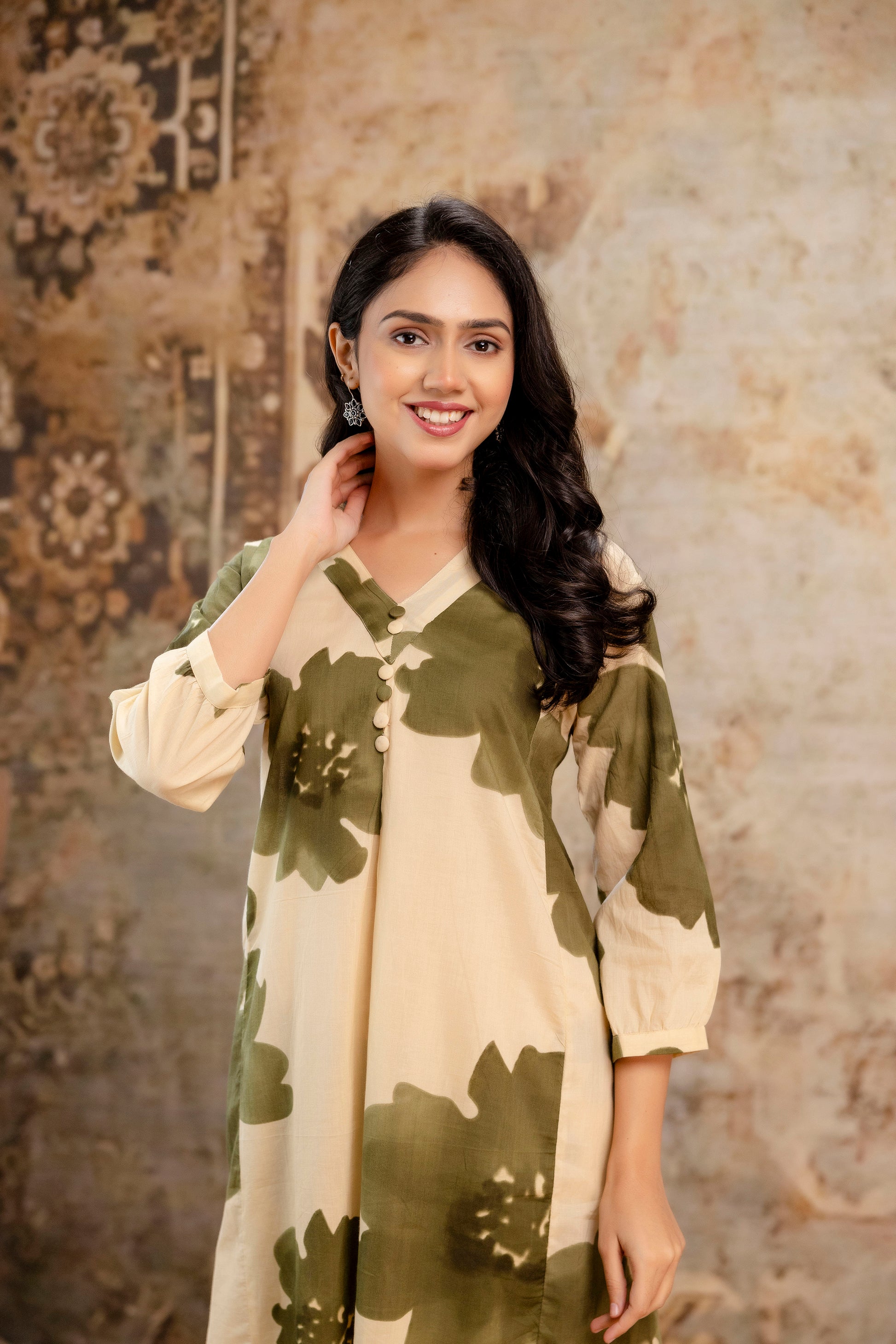 Beige cotton kurti with oversized green floral print

V-neckline with looped fabric buttons for detailing

3/4th sleeves with subtle gathers at the cuffs

Lightweight, breathable fabric ideal for summer wear

Modern ethnic wear with a relaxed straight silhouette