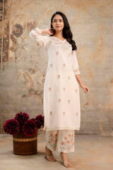 Tanauri cream cotton kurti set with embroidered neckline and floral pants
Elegant woman in off-white cotton kurti and printed pants by Tanauri
Cream ethnic kurti with light floral embroidery and lace trim from Tanauri