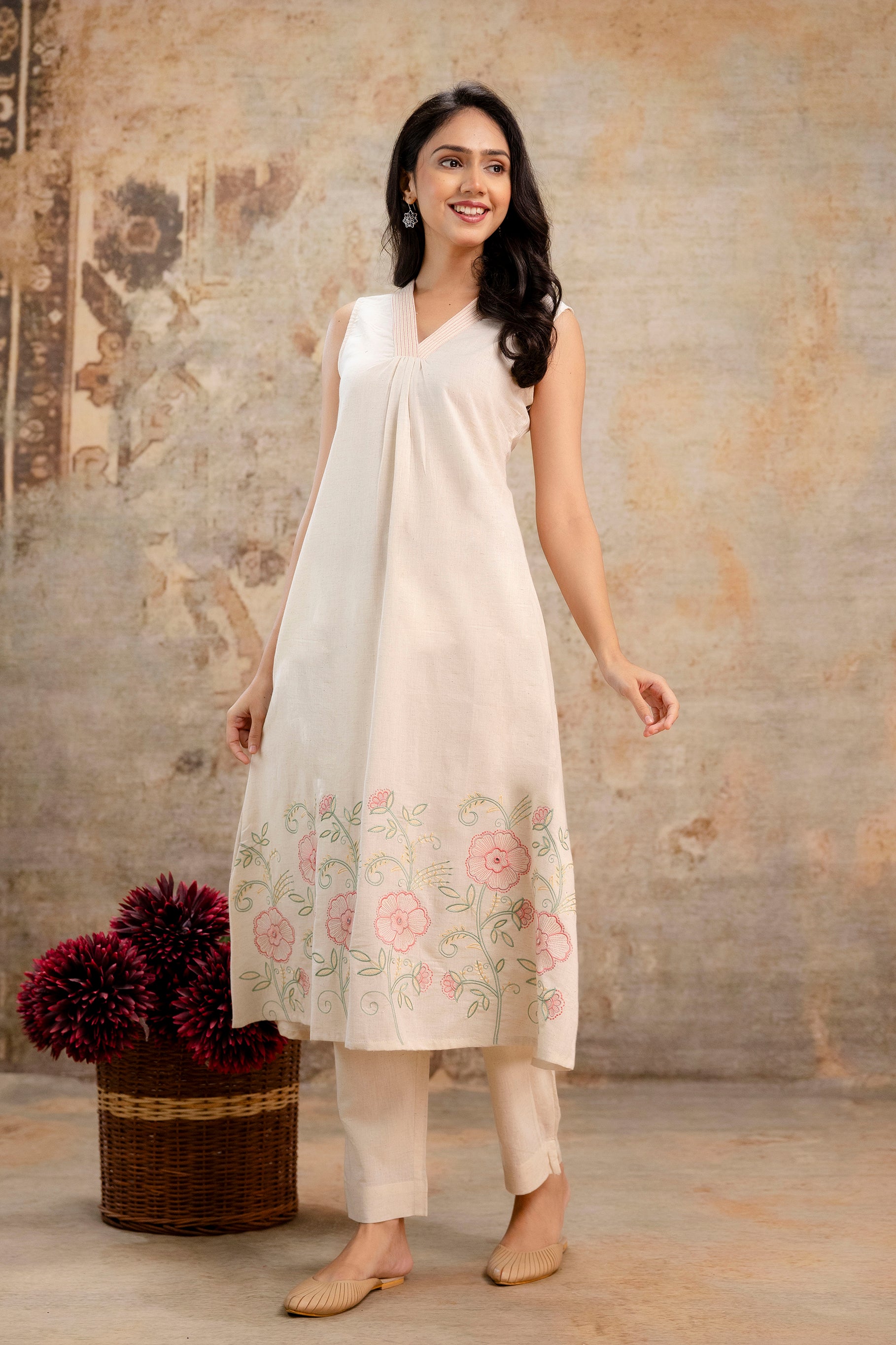 Elegant ivory sleeveless Tanauri cotton kurti with a soft pleated front.

Features floral pastel embroidery at the bottom for a delicate finish.

Styled with plain ivory tapered pants, perfect for minimalist looks.

Best for festive brunches, daily wear, and light celebrations.

Keywords: Tanauri cotton kurti, sleeveless kurti set, pastel embroidery kurti, elegant Indian outfit.