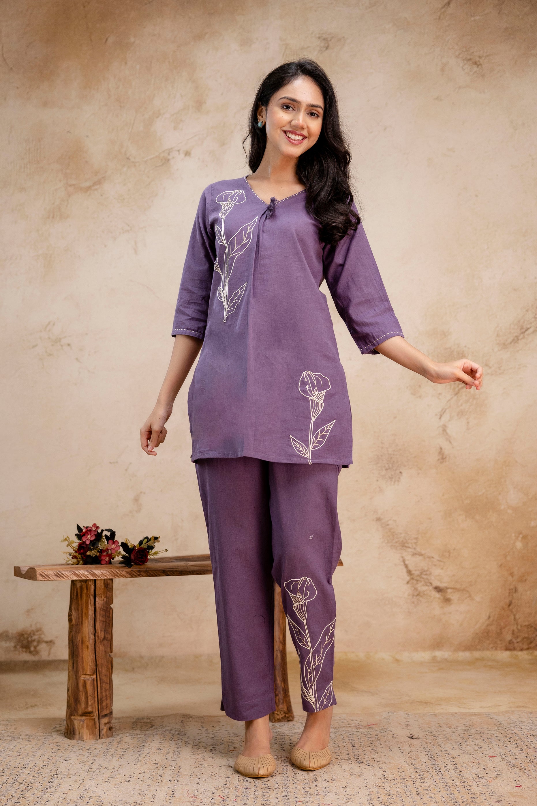 Purple co-ord set featuring white floral embroidery on the kurti and pant.

Straight-fit 3/4 sleeve top with a modest round neckline.

Matching straight pants with floral motif near hemline.

Made from comfortable cotton-linen blend.

Perfect for casual ethnic or fusion wear.

Keywords: embroidered co-ord set, purple kurti set, floral cotton kurti, women's ethnic wear.