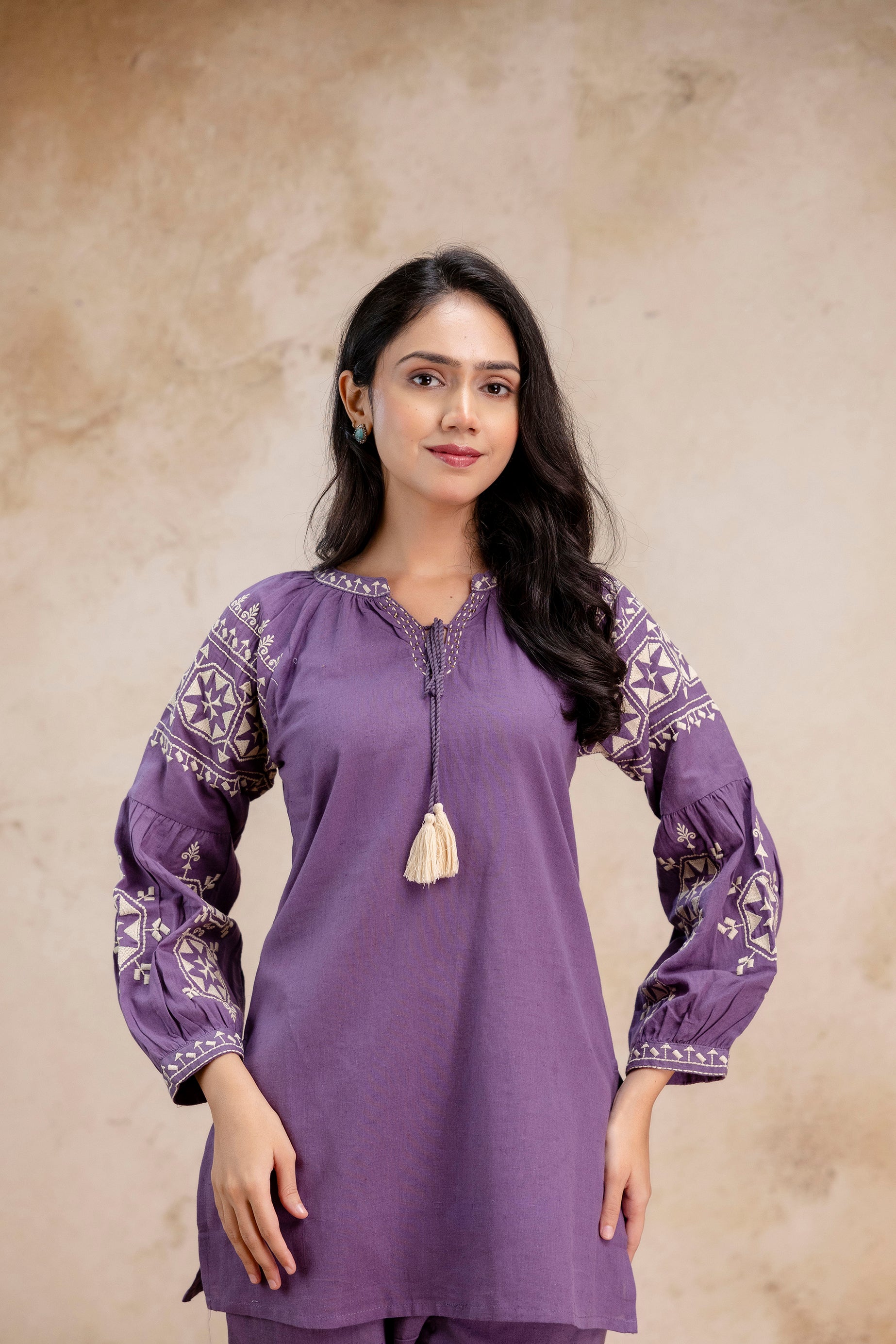 1. Close-up of Tanauri lavender cotton kurti with embroidered balloon sleeves and tassel tie  
2. Tanauri ethnic lavender kurti with boho full sleeves – front portrait view  
3. Lavender cotton kurti with floral embroidery on sleeves and neckline – Tanauri outfit  
4. Front view of embroidered lavender kurti in cotton with tassel detail by Tanauri  
5. Tanauri lavender kurti for women with balloon sleeves and ethnic threadwork  
6. Model wearing Tanauri cotton kurti in lavender with sleeve embroidery