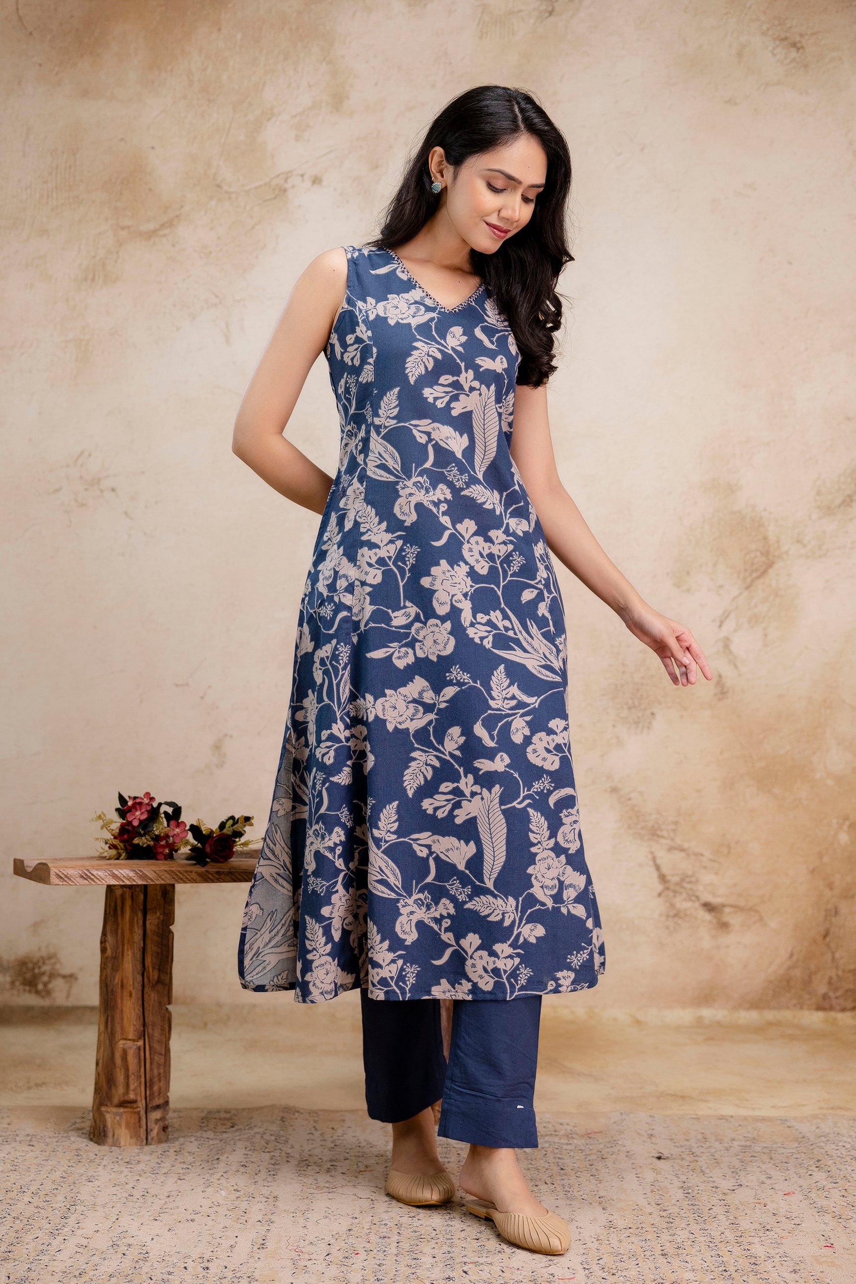 1. Tanauri indigo cotton kurti with beige floral print – sleeveless A-line design  
2. Sleeveless floral cotton kurti by Tanauri in indigo with straight navy pants  
3. Tanauri cotton kurti set in indigo blue – sleeveless style with ethnic motifs  
4. Elegant indigo cotton kurti outfit by Tanauri with floral block print  
5. Model wearing Tanauri sleeveless indigo cotton kurti with straight pants  
6. Flared indigo Tanauri kurti in breathable cotton fabric with beige print  
7. Tanauri ethnic cotton kurti 