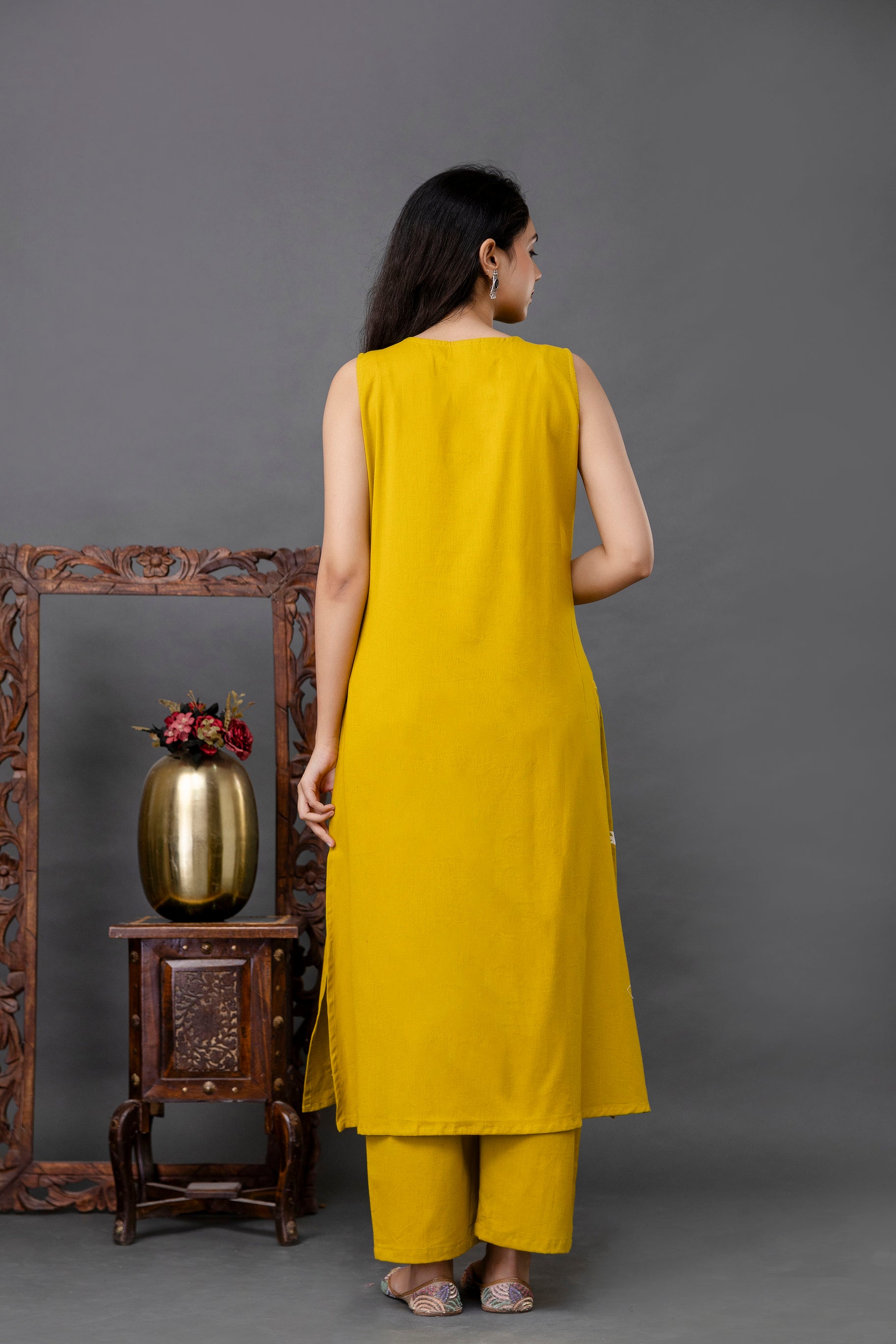 Back view of a sleeveless mustard yellow kurti in solid cotton fabric

Straight-cut design with long length and clean finishing

Deep round back neckline and side slits for ease and movement

Seamless, minimal look ideal for styling with printed or plain bottoms

Perfect for everyday ethnic wear or casual fusion looks
