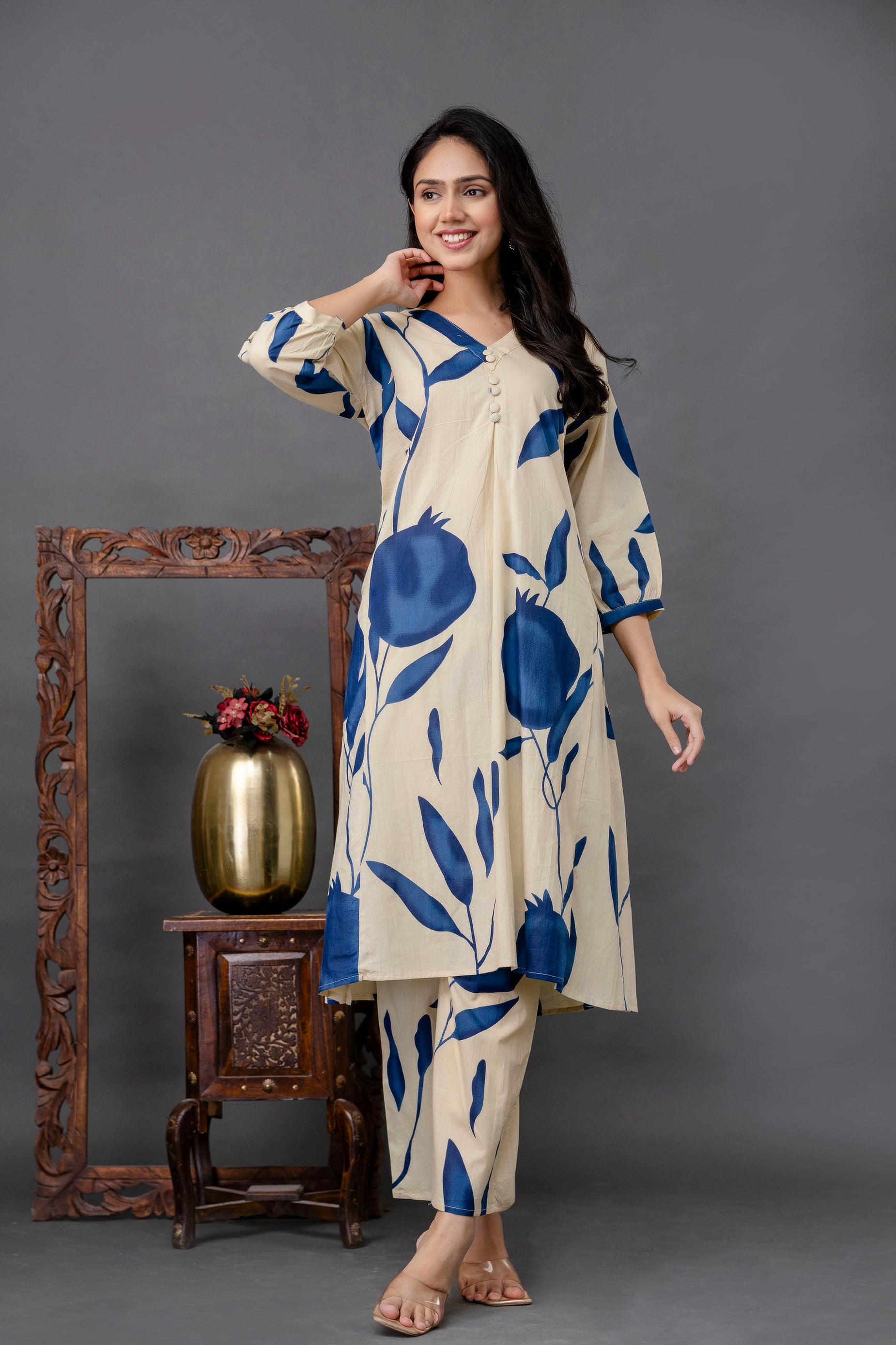 Beige A-line kurta with oversized navy blue botanical print

Angrakha-style neckline with small center buttons and soft pleats

Three-quarter sleeves with coordinated print

Paired with matching straight-cut pants featuring the same blue print

Model styled simply against a muted grey background to emphasize the design