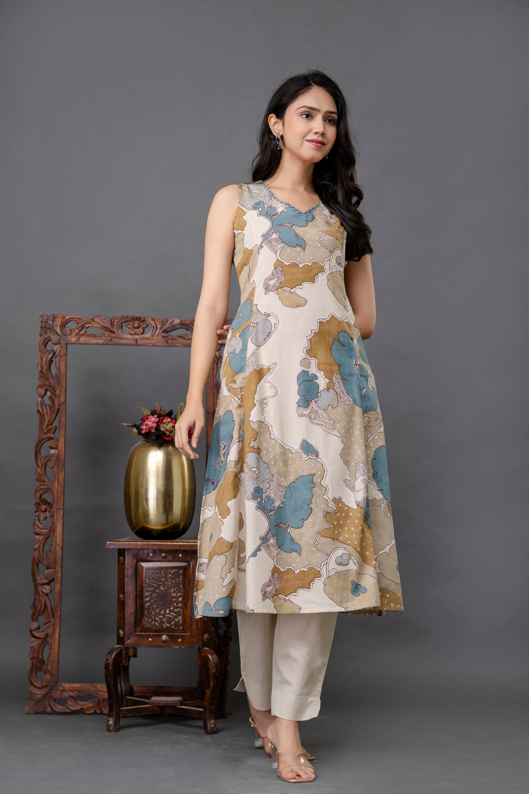Sleeveless A-line kurti in off-white base with artistic abstract floral print in teal blue, mustard, and beige tones

Features a subtle V-neckline and mid-length hemline for a sleek, flattering silhouette

Paired with ivory straight pants, enhancing the modern ethnic style

Made from soft, breathable fabric – ideal for summer casuals or festive wear

A chic printed kurti set perfect for office, brunch, or contemporary ethnic outings