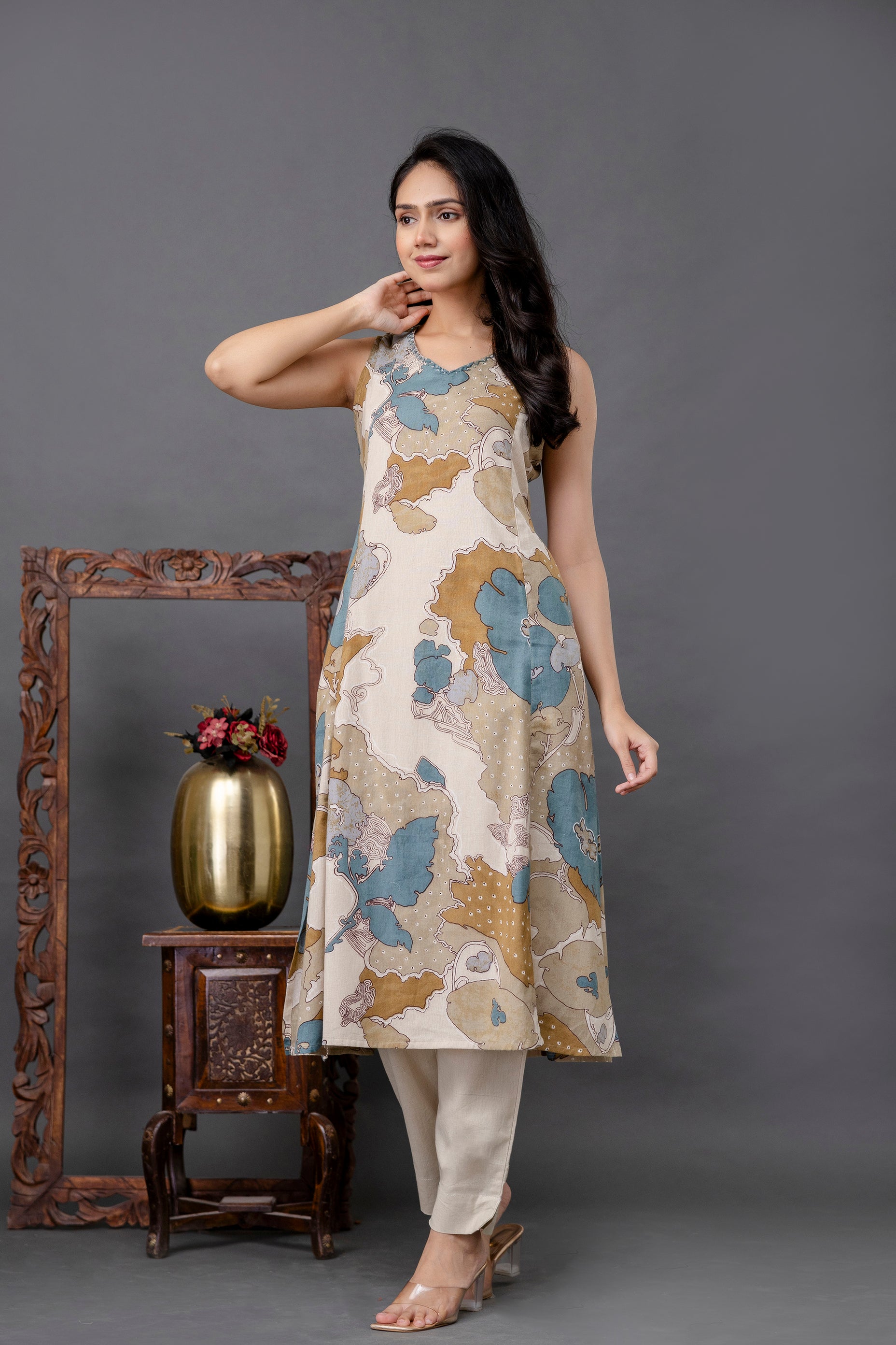 Sleeveless beige kurti with multicolor abstract floral print in teal blue, mustard, and off-white hues

Features a sharp V-neck and flared A-line cut for an elegant, breezy silhouette

Lightweight and breathable cotton fabric ideal for casual summer wear

Styled with ankle-length off-white straight pants for a balanced ethnic-contemporary look

Perfect printed kurti for daily wear, office, festive brunches, or stylish daytime events