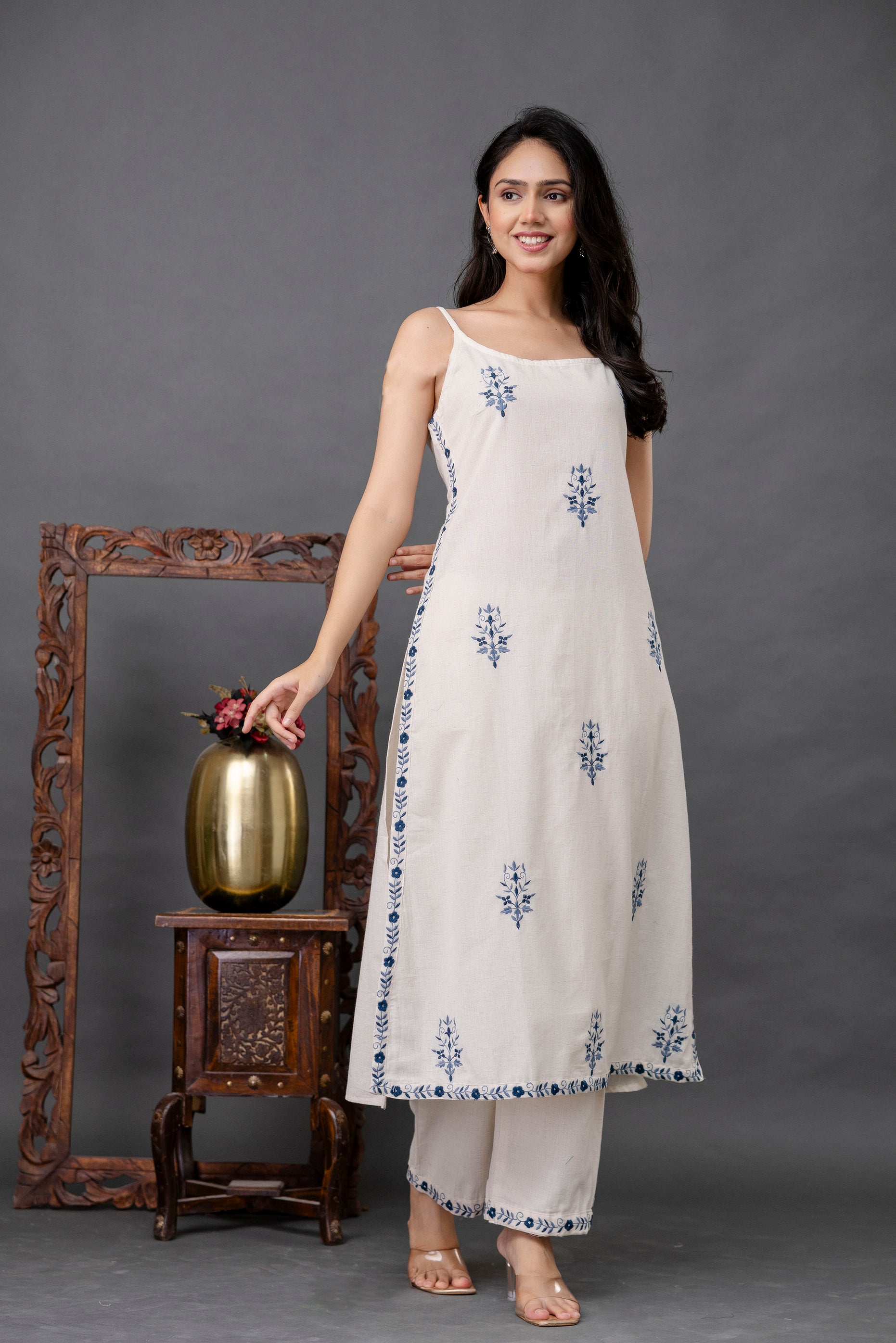 Sleeveless ivory kurti featuring delicate navy blue floral embroidery

Straight-fit silhouette with a flowy hem and side slits for comfort

Fine border detailing along side seams and hem adds a traditional touch

Lightweight cotton fabric ideal for warm weather and casual occasions

Elegant ethnic kurti perfect for summer wear, festive styling, or everyday elegance