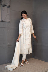 A woman modeling 'Moon Dew Dupatta Set' by Tanauri, featuring a white cotton kurti and trousers with delicate multicolored embroidery, holding a textured, white dupatta