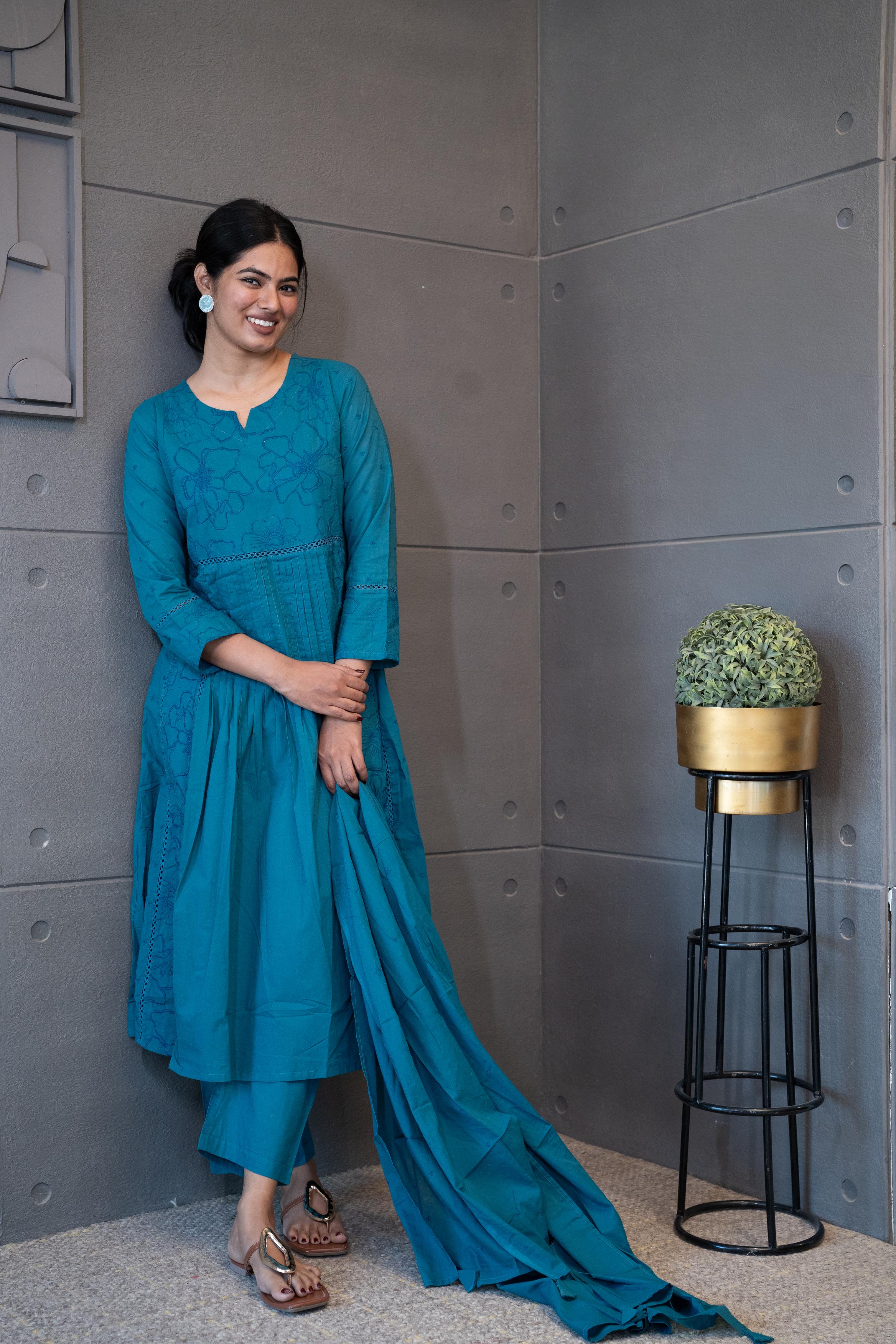 A woman modeling 'Blue Oasis Dupatta Set' by Tanauri, featuring a blue cotton kurti and trousers with delicate tonal floral thread embroidery, holding a textured, blue dupatta
