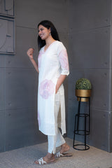 A woman modeling 'Pink Thread Kurta Set' by Tanauri, featuring a white cotton kurti and trousers with delicate pink floral embroidery