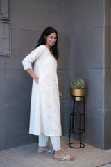 Tanauri Geometric Embroidered Cream Kurta Set, folded in packaging, showcasing colorful blue, pink, and yellow geometric embroidery on a light cotton kurti