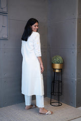Model wearing Tanauri Geometric Embroidered Cream Kurta Set, displaying full view of kurti with geometric embroidery and matching cream pants in a casual setting