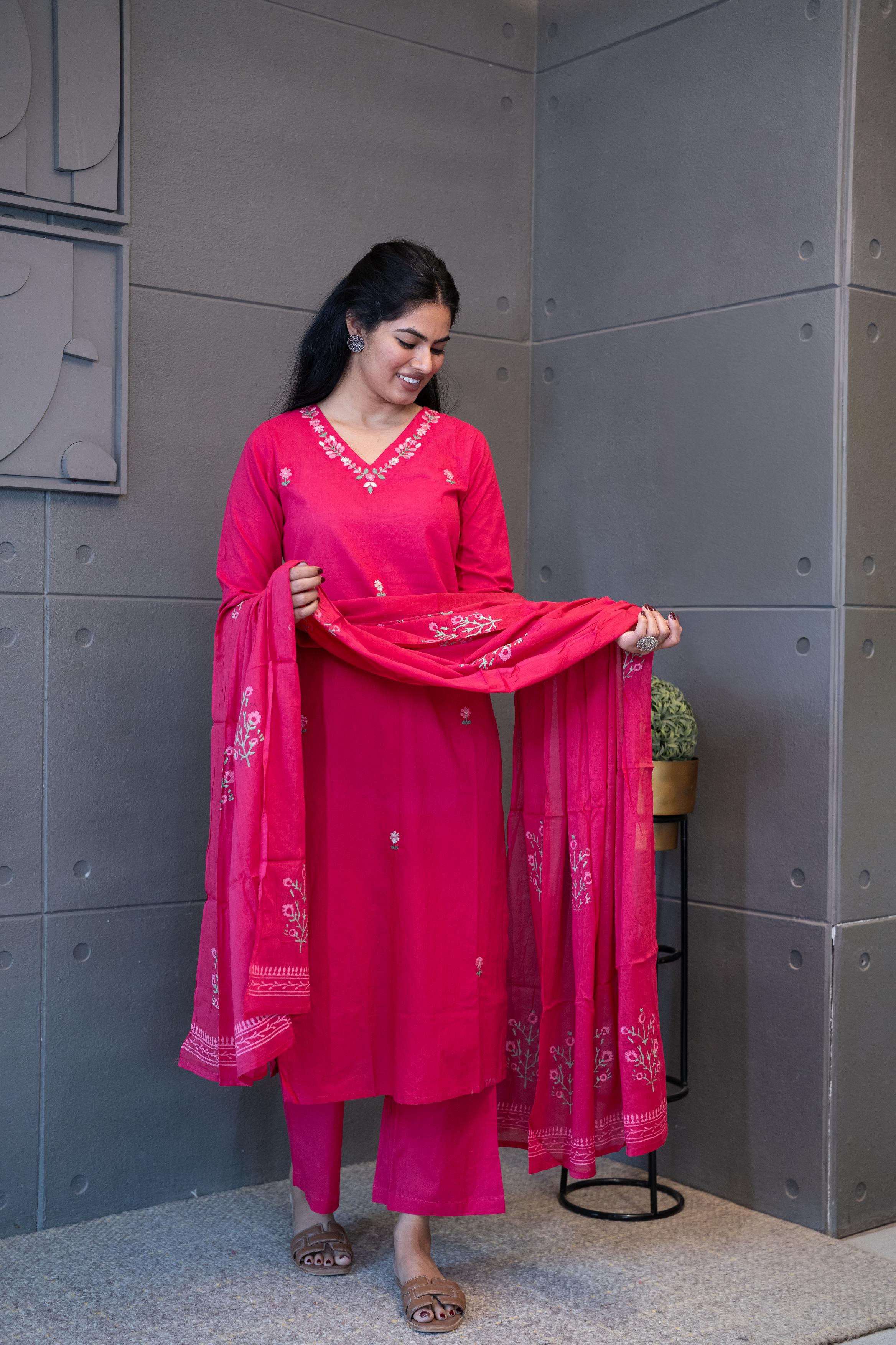 A woman modeling 'Noori Dupatta Set' by Tanauri, featuring a pink cotton kurti and trousers with delicate floral embroidery, holding a textured, pink dupatta