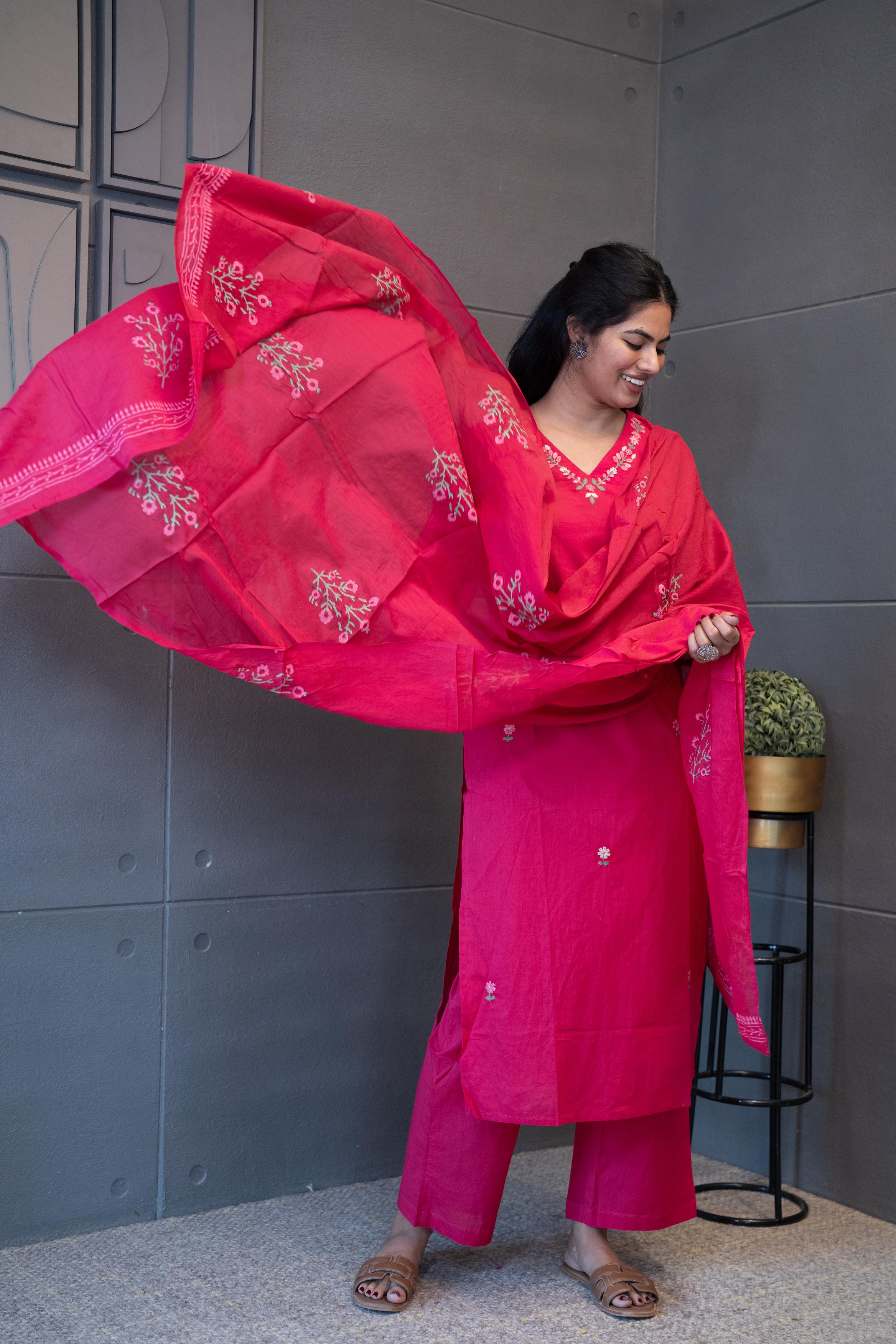 A woman modeling 'Noori Dupatta Set' by Tanauri, featuring a pink cotton kurti and trousers with delicate floral embroidery, holding a textured, pink dupatta