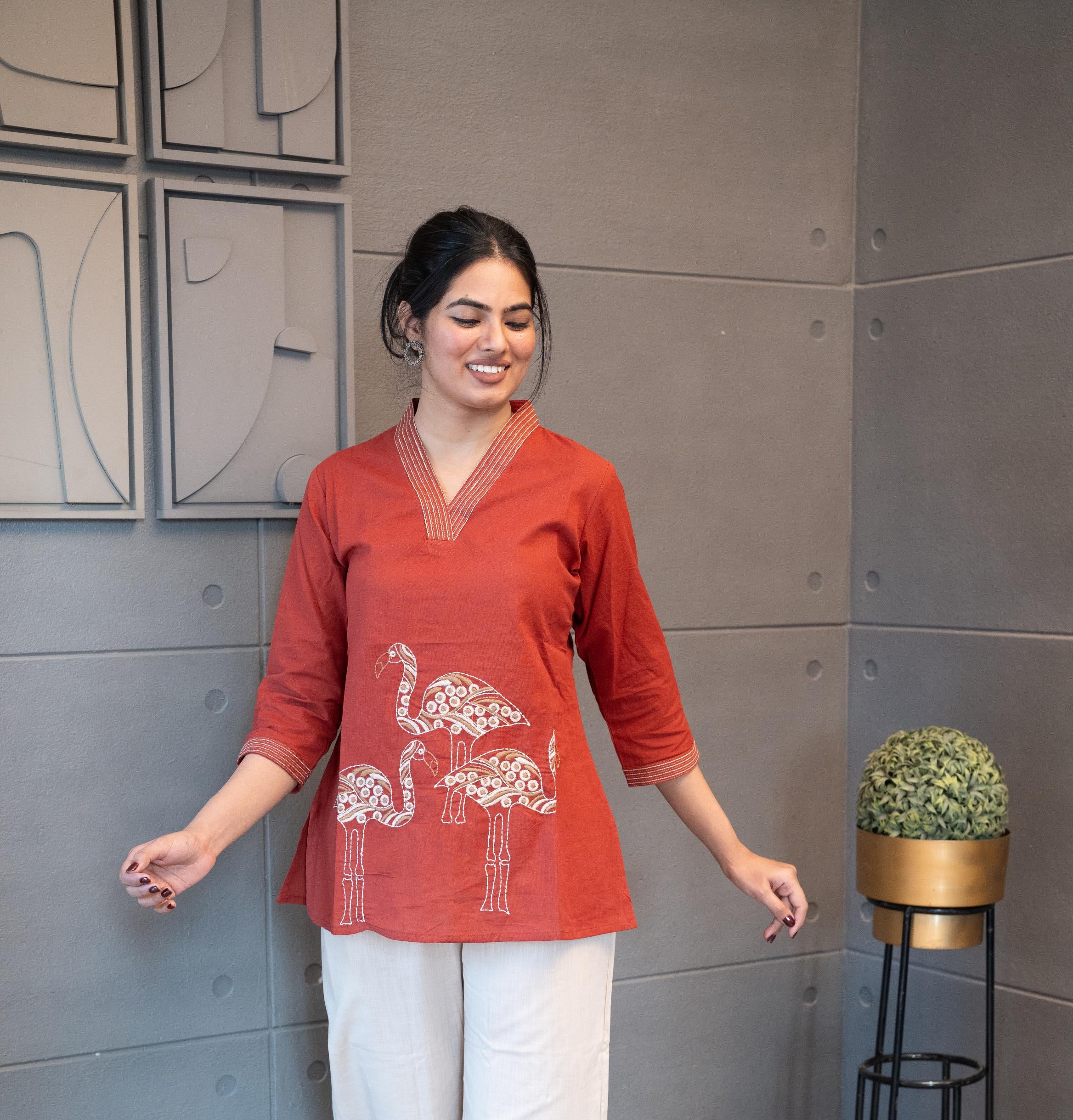 Tanauri Mastani Short Kurti/Top, folded in clear packaging, showcasing a vibrant brick red cotton tunic with prominent white vertical stripe detailing on the V-neckline