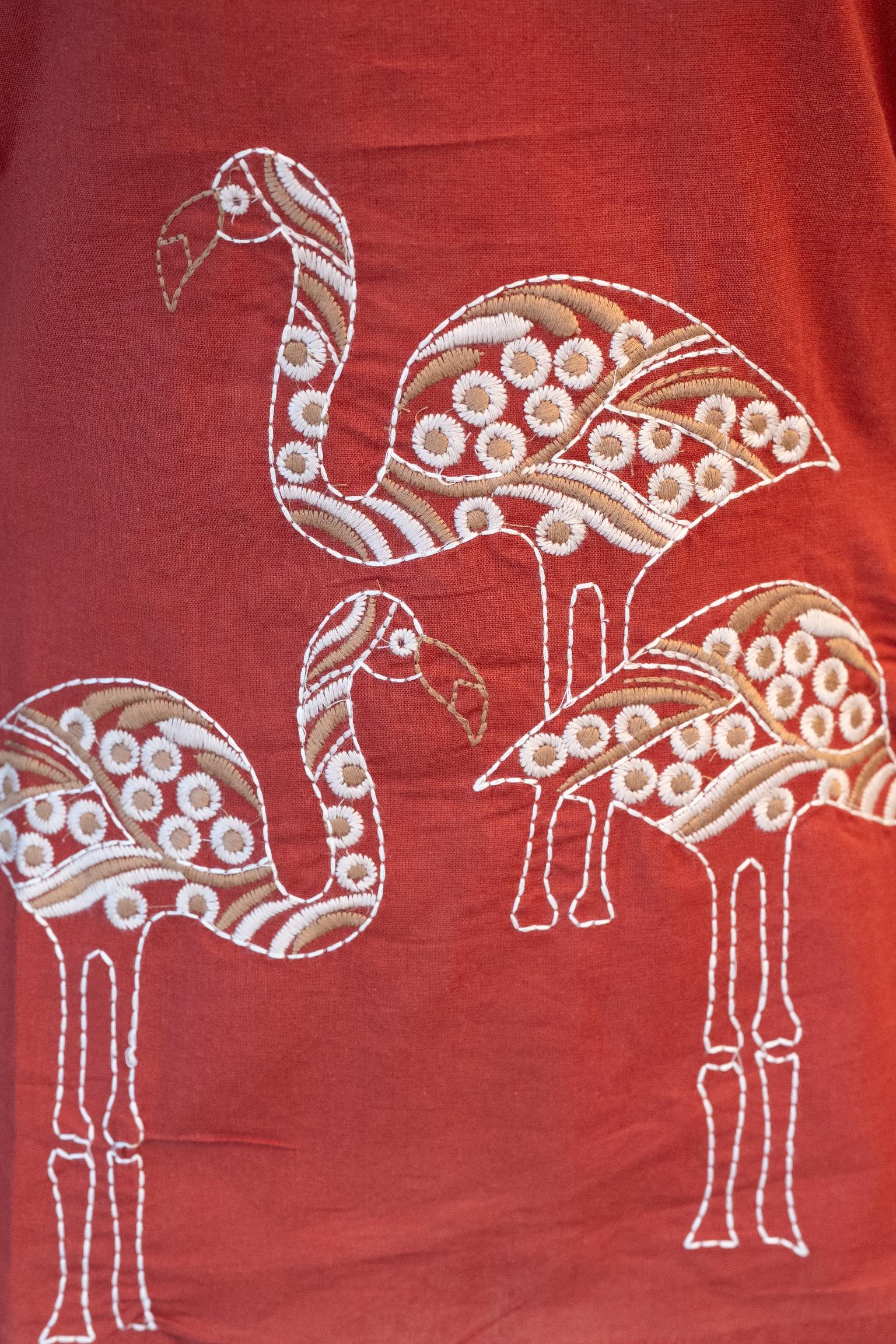 Close-up of the V-neckline of the Tanauri Mastani Short Kurti/Top, highlighting the bold white vertical stripe embroidery/detailing against the brick red fabric