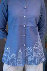 Close-up of the front placket and subtle decorative buttons on the periwinkle blue fabric of the Tanauri Blue Cityscape Short Kurti/Top
