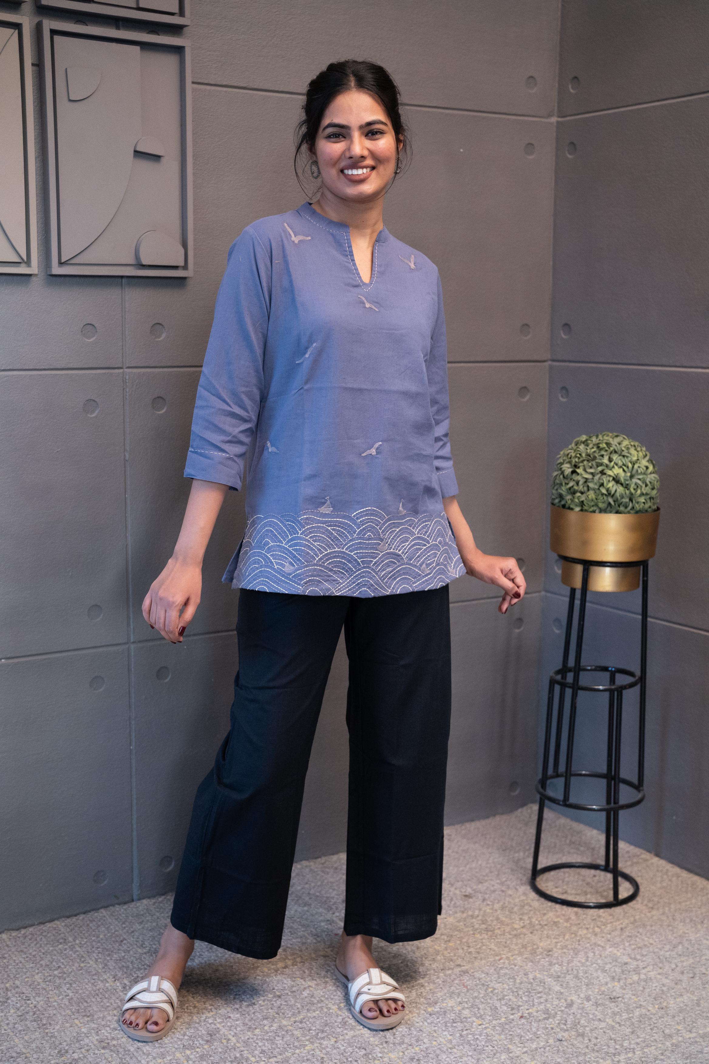 Model wearing Tanauri Grey Bird Short Kurti/Top, displaying the periwinkle cotton short kurti with grey bird designs, paired with white jeans for a charming casual look