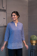Model wearing Tanauri Grey Bird Short Kurti/Top, displaying the periwinkle cotton short kurti with grey bird designs, paired with white jeans for a charming casual look