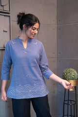 Tanauri Grey Bird Short Kurti/Top, folded in clear packaging, showcasing a periwinkle blue cotton tunic with light grey bird motifs and matching V-neck stitching