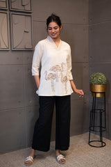 Detailed view of the soft, breathable cream cotton fabric texture of the Tanauri Swan Short Kurti/Top