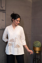 Model wearing Tanauri Swan Short Kurti/Top, displaying the cream cotton short kurti/top with V-neck detailing paired with jeans, for a casual elegant look