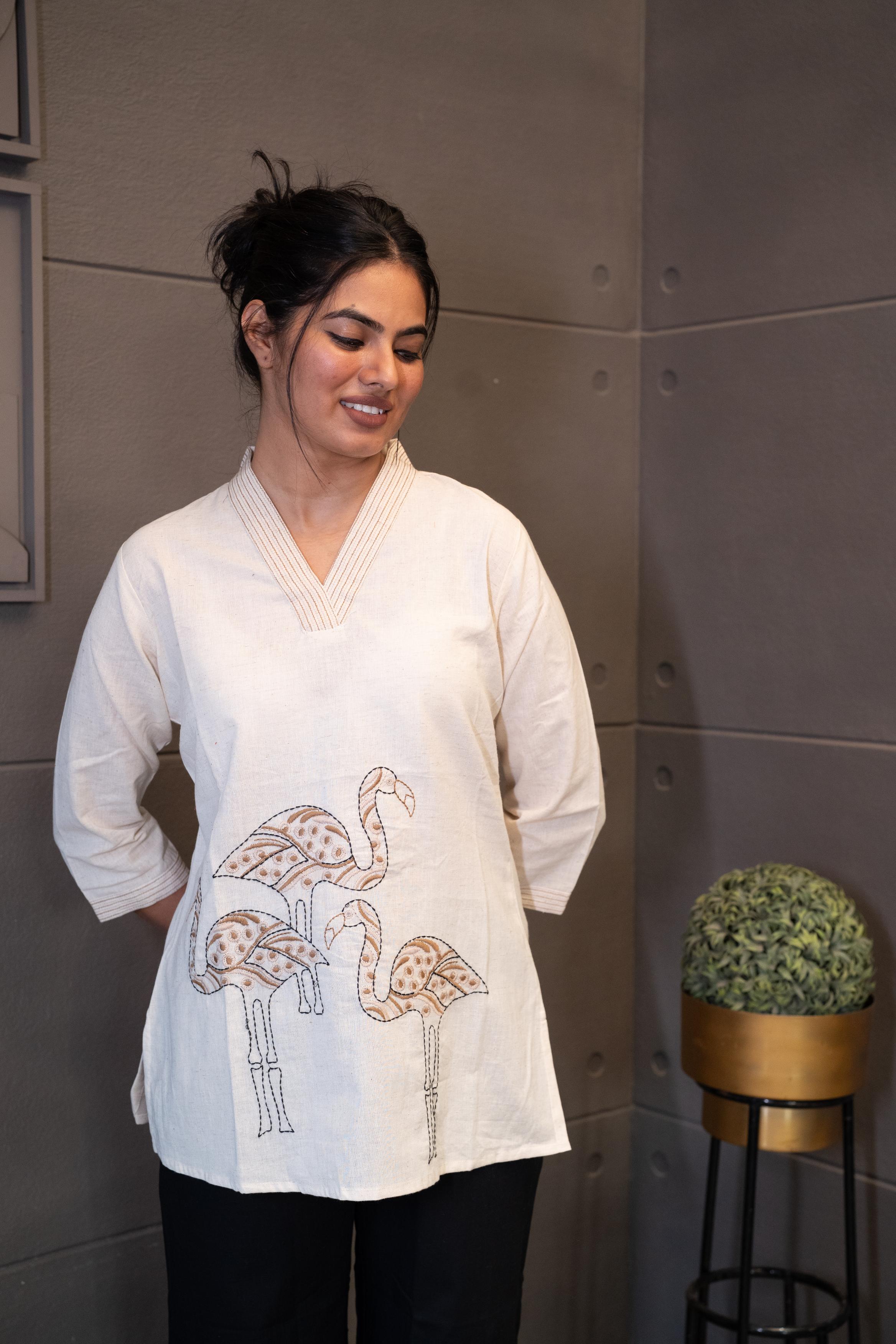 Tanauri Swan Short Kurti/Top, folded in clear packaging, showcasing an off-white/cream cotton tunic with subtle vertical detailing on the V-neckline