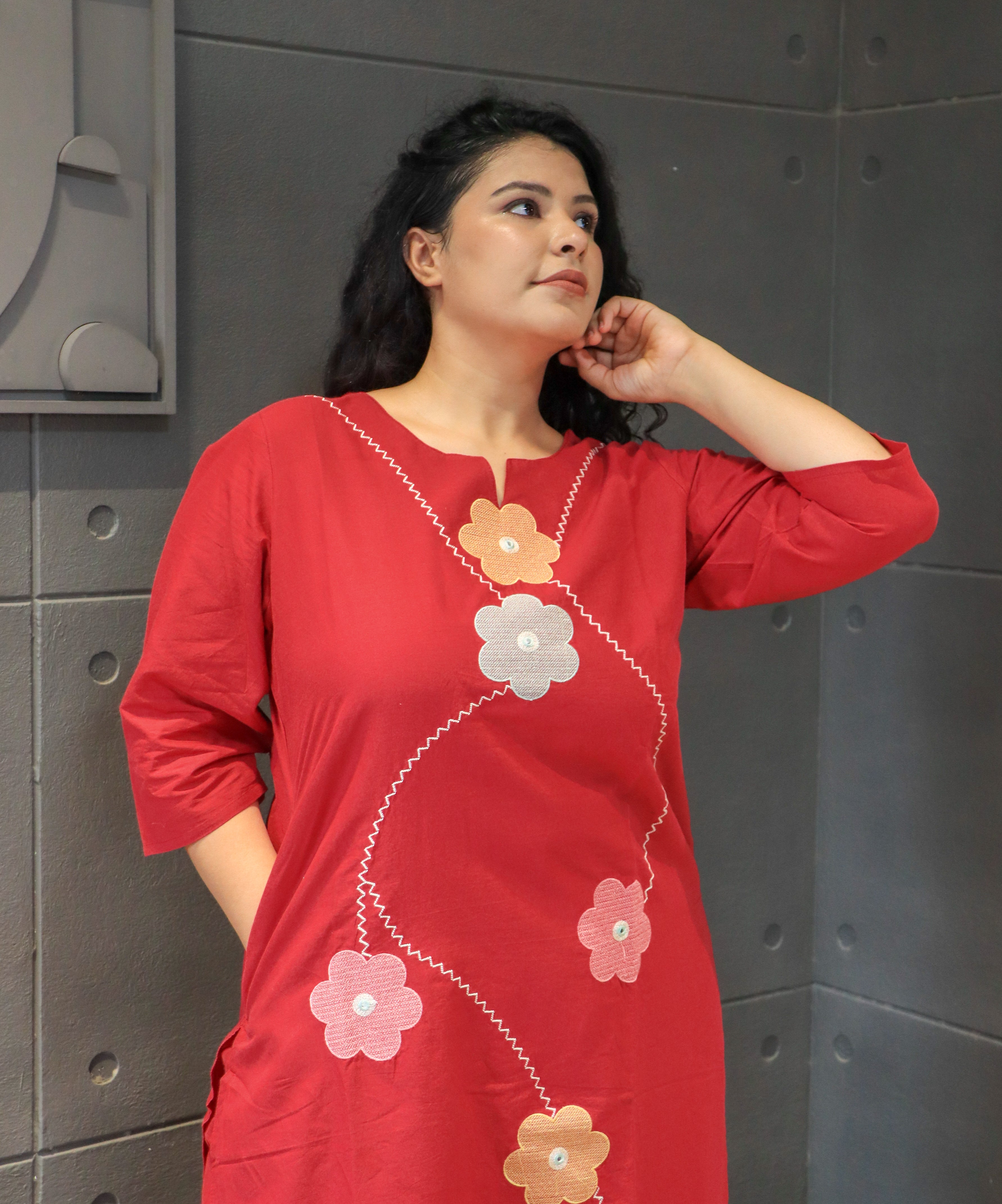 Cotton fabric close-up showing red floral applique work from Tanauri.