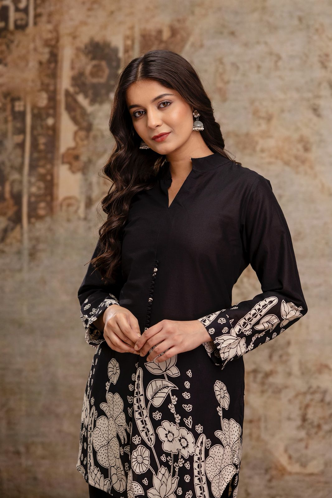1. Close-up of black cotton kurti with white floral block print on sleeves  
2. Black ethnic kurti for women with mandarin collar and handcrafted buttons  
3. Model wearing black floral printed kurti – portrait front view  
4. Elegant black kurti with printed cuffs and hem – cotton ethnic wear  
5. Women’s black kurti in breathable cotton with traditional block motifs  
6. Front upper view of black kurti with detailed floral prints – close-up  
7. Black kurti for festive and casual wear with ethnic sleeve 