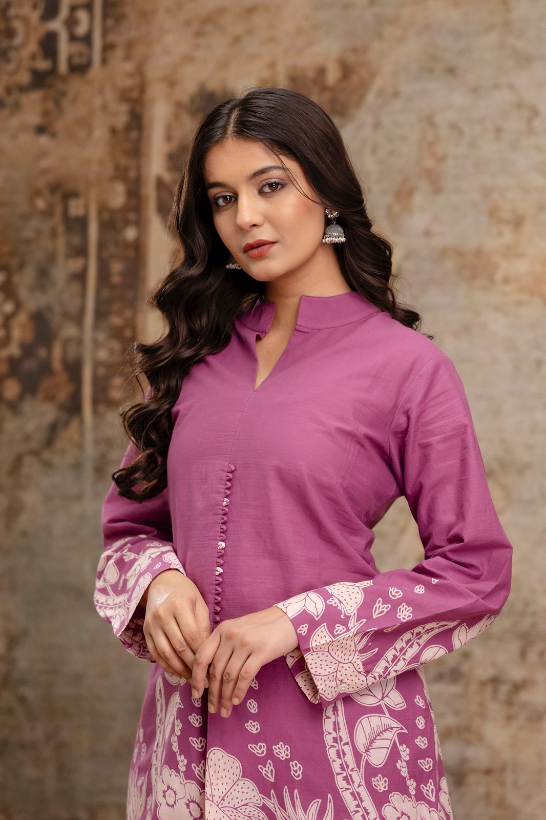1. Close-up of mauve floral kurti with mandarin collar and button details  
2. Mauve kurti with white floral print and full sleeves – model front pose  
3. Front view of cotton kurti in mauve with ethnic sleeve print  
4. Elegant mauve kurti with detailed cuffs and soft gathers – close-up  
5. Stylish ethnic kurti in mauve with printed sleeve design and collar  
6. Woman wearing mauve printed kurti with minimal makeup and jhumkas  
7. Kurti neckline and sleeve detailing in mauve cotton ethnic outfit  
